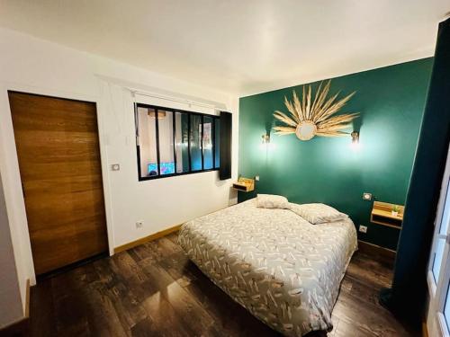 a bedroom with a bed and a green wall at Appartement Cosy in Perpignan