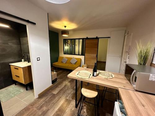 a kitchen and living room with a table and a couch at Appartement Cosy in Perpignan