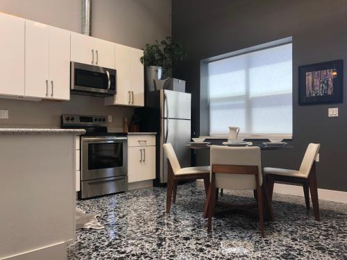 a kitchen with white cabinets and a table and chairs at Petaluma Warehouse Lofts, Unit B in Petaluma