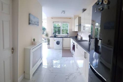 a large white kitchen with a washer and dryer at 3 Bedroom 3 Bathroom House, Dublin in Lucan