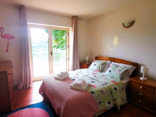 um quarto com uma cama e uma grande janela em CASA CAPUCINE em Rio Caldo