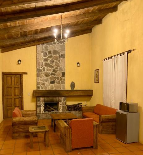 uma sala de estar com um sofá e uma lareira em Cabañas Rancho La Laguna em Zacatlán