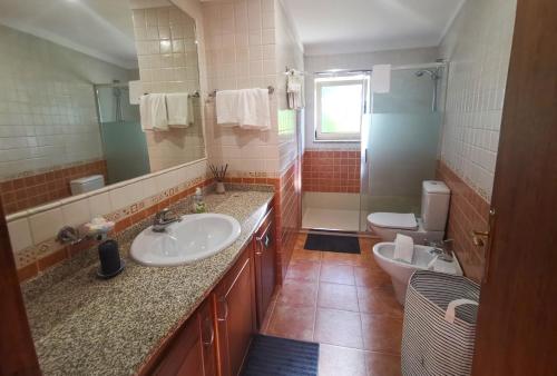 uma casa de banho com 2 lavatórios e um WC em CASA CAPUCINE em Rio Caldo