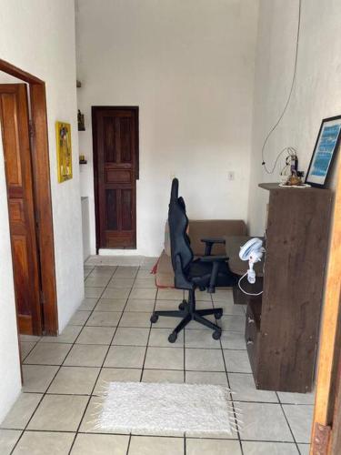 a room with a chair and a desk and a door at Casa de Dandá in Porto Seguro