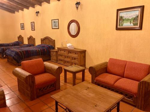 uma sala de estar com mobiliário, uma cama e uma mesa em Cabañas Rancho La Laguna em Zacatlán