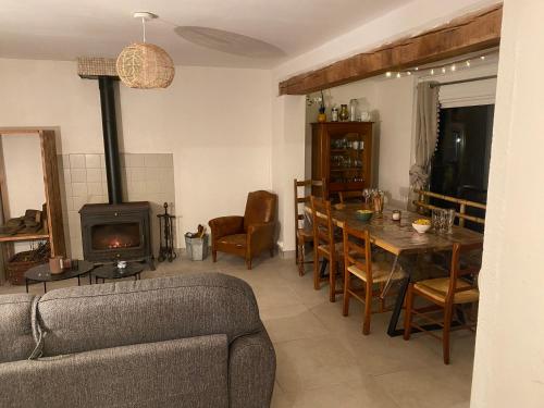 - un salon avec un canapé, une table et une cheminée dans l'établissement La Petite Maison au bord de l’étang, à Chirac