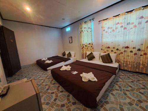 ein Hotelzimmer mit 2 Betten und Handtüchern darauf in der Unterkunft ไทยกันเอง ริมโขง in Chiang Khan