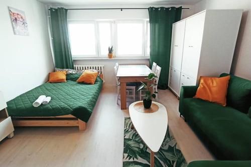 a living room with a green couch and a table at Apartament Mokotów in Warsaw