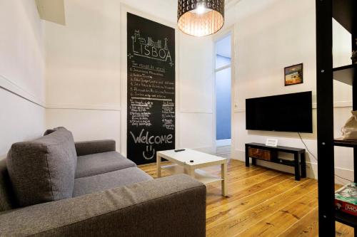 a living room with a couch and a tv at Ambiente Hostel in Lisbon