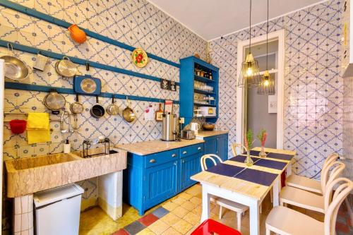 リスボンにあるアンビエンテ ホステルのキッチン(青いキャビネット、テーブル、椅子付)