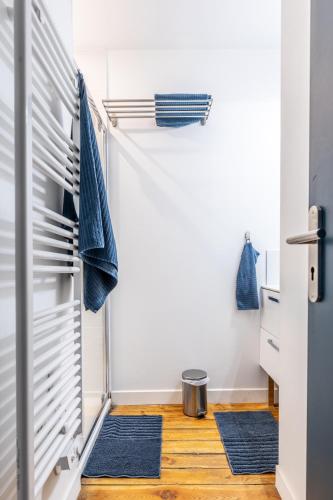 - une salle de bains avec 2 tapis bleus au sol dans l'établissement La maison de Vallières, à Clermont-Ferrand