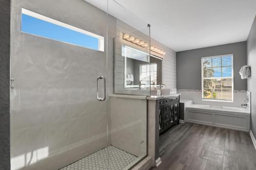 a bathroom with a shower and a sink and a tub at Themed Luxury 6BR Getaway with Resort Amenities in Orlando