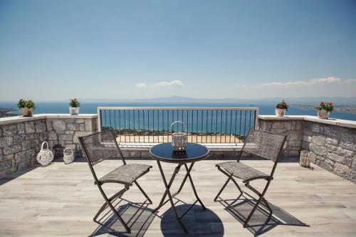 a patio with a table and chairs on a balcony at Petra Thea in Kalamata