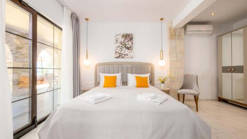 a bedroom with a large white bed with orange pillows at Pamina Mare in Nea Skioni