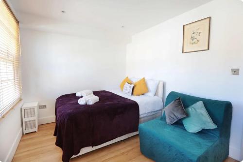 a bedroom with a bed and a blue chair at Lovely Private Bedrooms in Euston, Central London in London
