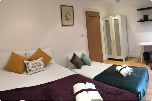 a bedroom with two beds with pillows at Lovely Private Bedrooms in Euston Station - 121 in London