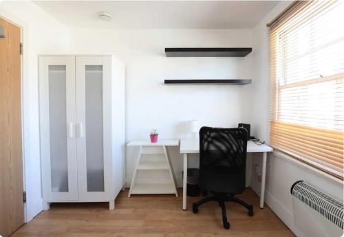 a desk and a chair in a room with a window at Lovely Private Bedrooms in Euston, Central London in London