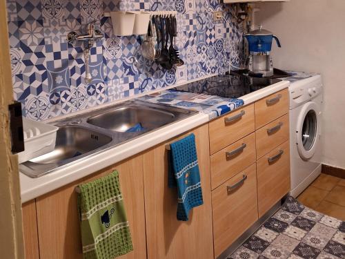 a kitchen with a sink and a washing machine at Michelle Apartment in Bari
