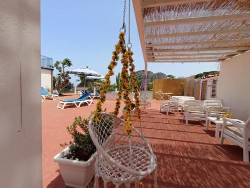 a patio with white chairs and a plant at BorgoMarino's Room in Cefalù