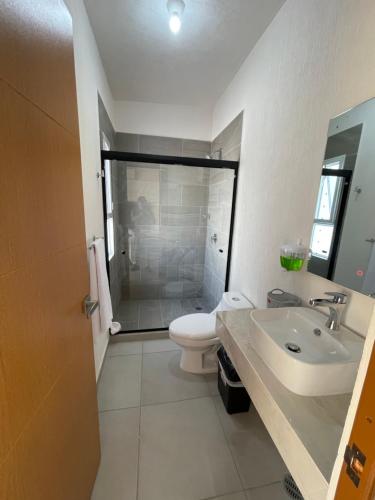 a white bathroom with a toilet and a sink at Bonita casa muy cómoda y con piscina in Naranjo