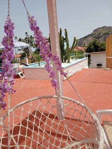 a chain link fence with purple flowers on it at BorgoMarino's Room in Cefalù