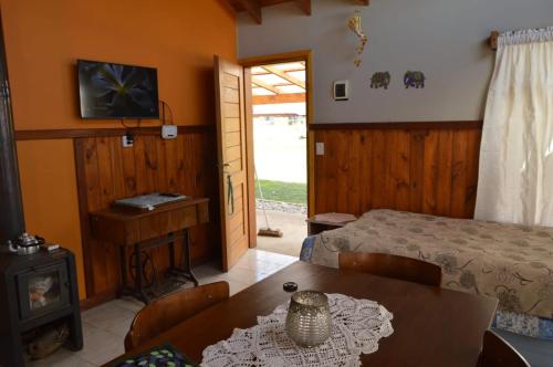 - une chambre avec un lit et une table ainsi qu'une chambre avec une cheminée dans l'établissement Cabaña Piedra Hermosa, à Ñirihuau
