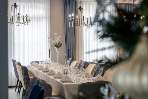 a long table in a room with chairs and glasses at Aquamarine - Beach & SPA Hotel- All inclusive in Kranevo