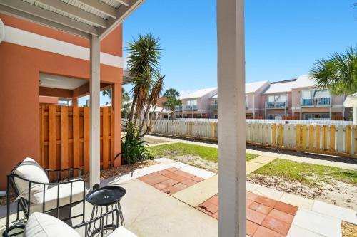 a patio with chairs and a table and a fence at !! SNOWBIRD MONTHLY RATE 2900 !! 5min walk 2 Miramar Beach, Mins to Shopping, Steps to Pool, Patio and Yard, Dog Friendly, 1GB Wifi in Destin