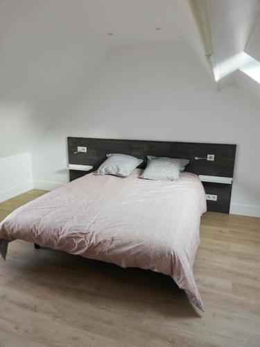 une chambre avec un grand lit dans une pièce blanche dans l'établissement La Vaillante, à Saint-Valery-sur-Somme