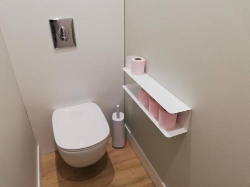 een badkamer met een wit toilet en een aantal roze dozen bij La Vaillante in Saint-Valery-sur-Somme