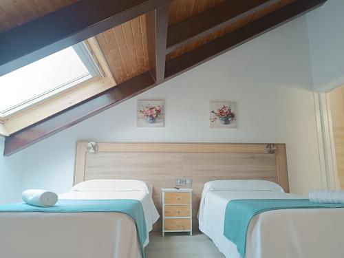 a bedroom with two beds and a window at Apartamentos turisticos Ávila Puerta del Carmen 0-3 in Avila