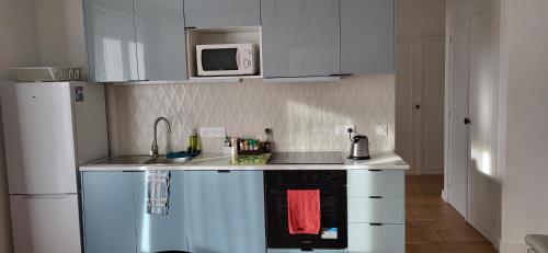 a small kitchen with a sink and a microwave at Paris/La Défense 10' en train 2 CHB in Colombes