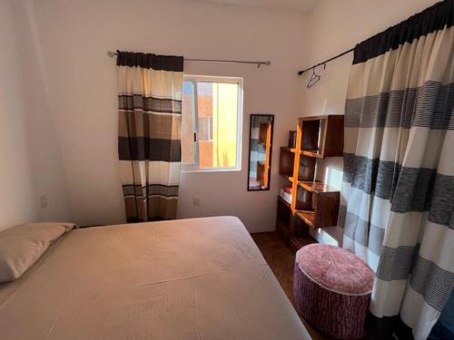 a bedroom with a bed and a window at Casa Mañana in Puerto Escondido