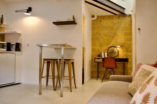 ein Wohnzimmer mit einem Tisch und einem Sofa in der Unterkunft Joli studio avec terrasse-jardin sur les toits, coeur historique in Montpellier