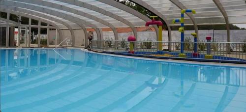 a large swimming pool with blue water at Mobilhome 6-8 personnes Clim in Saint-Jean-de-Monts