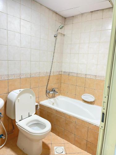 a bathroom with a toilet and a bath tub at 1BHK Sharjah Fully Furnished in Sharjah