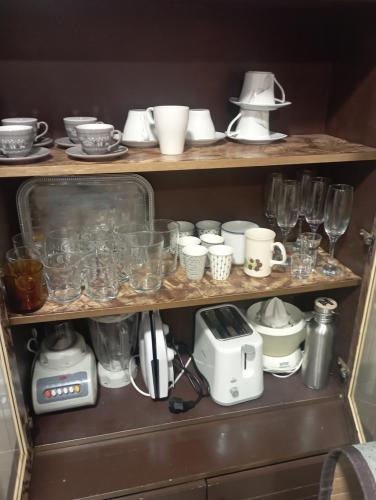 a shelf filled with glasses and other items in a kitchen at Apartamento completo, mascotas aceptadas in Arenales del Sol