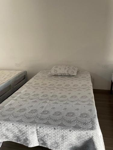 a bedroom with a bed with a white bedspread and a pillow at Ancestral Casa de Campo in Roldanillo