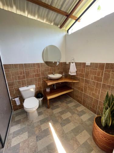 a bathroom with a toilet and a sink and a mirror at Ancestral Casa de Campo in Roldanillo