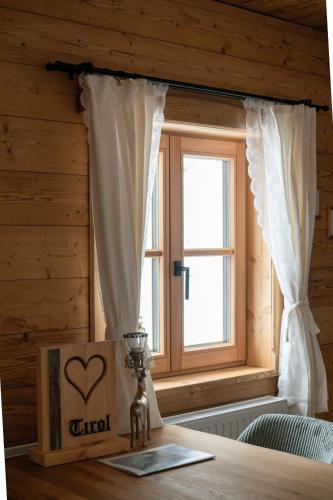 a table with a window and a box with a heart on it at Peer Alm in Navis