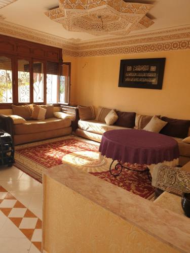 a living room with a couch and a table at Sidibouzid appartement in El Jadida