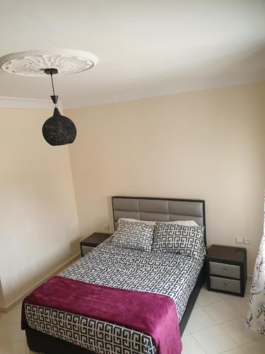 アル・ジャディーダにあるSidibouzid appartementのベッドルーム(紫の毛布付きのベッド1台付)