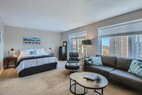 een slaapkamer met een bed en een bank bij Quiet Efficiency Condo - Downtown Minneapolis in Minneapolis