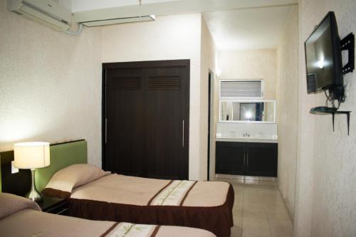 a hotel room with two beds and a door at Suites del Sol Hotel & Apartments in Mérida