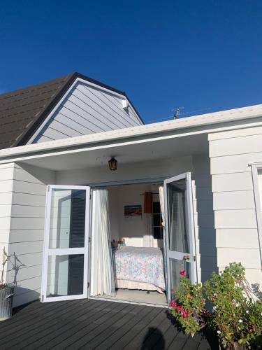 a room with a bed on the porch of a house at Home away from home in Christchurch