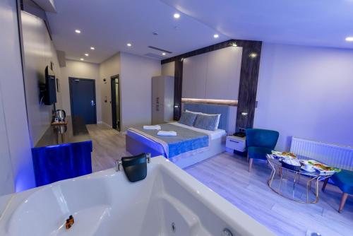 a large bathroom with a tub and a room with a bed at Meros Hotel in Istanbul