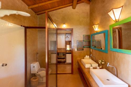 La salle de bains est pourvue de 2 lavabos et de toilettes. dans l'établissement Paraíso Casa Branca, à Arraial d'Ajuda