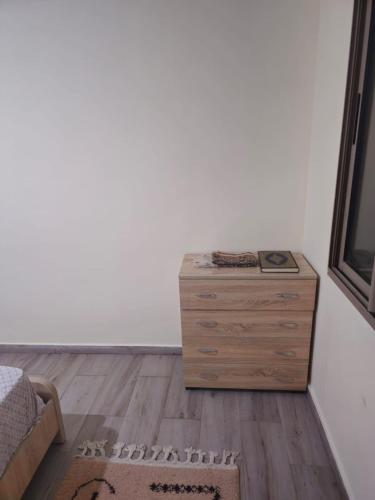 a bedroom with a wooden dresser and a bed at Apparemment Tout Confort Wifi in Essaouira
