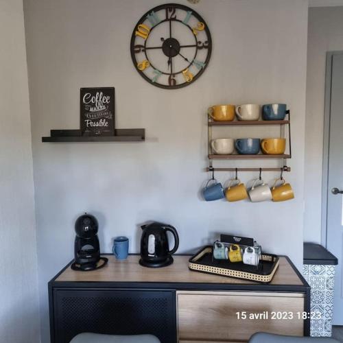 d'un réveil sur un mur au-dessus d'un bureau et d'une cafetière. dans l'établissement Appart moderne grande piscine Lacanau océan pinède, à Lacanau