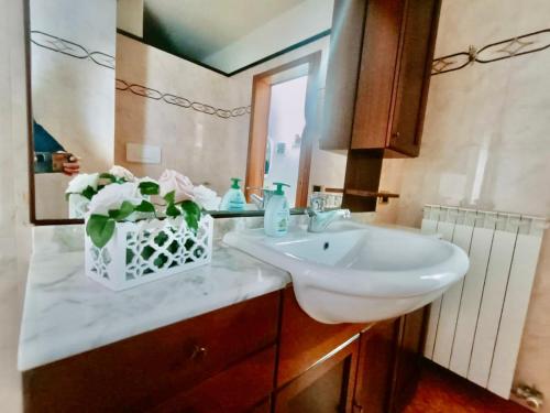 a bathroom with a sink and a vase with flowers at Appartamento Gardenia in Nardò